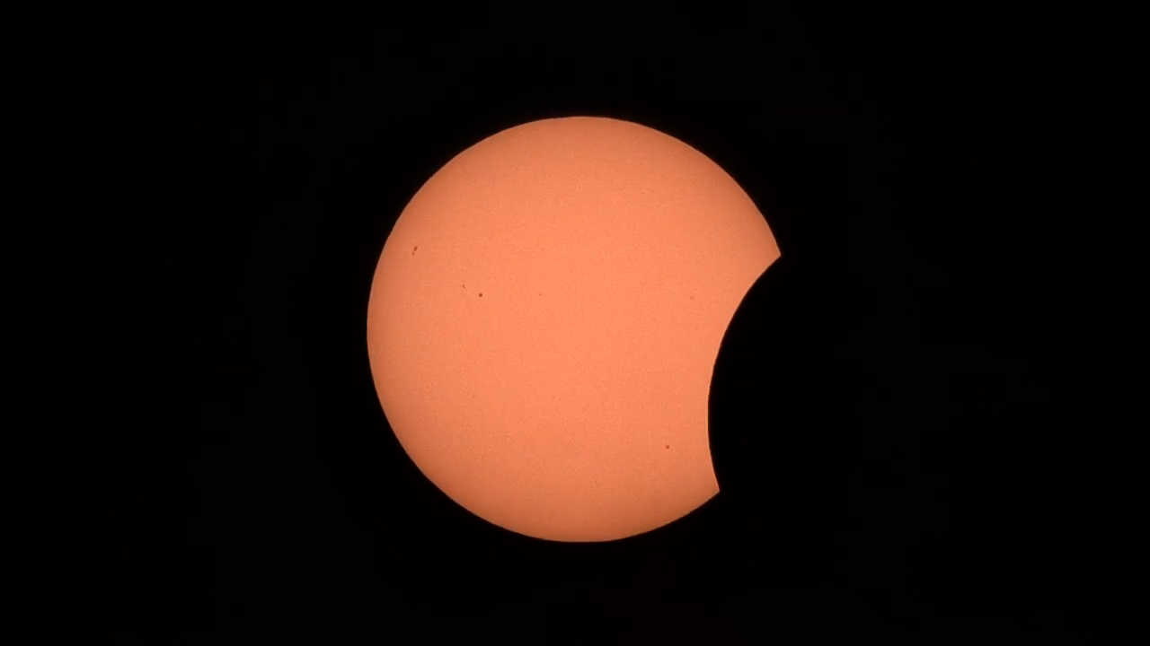Stage 1 of 5 · Early partial — the Moon's first bite out of the upper-right limb, sunspots still visible across the disc