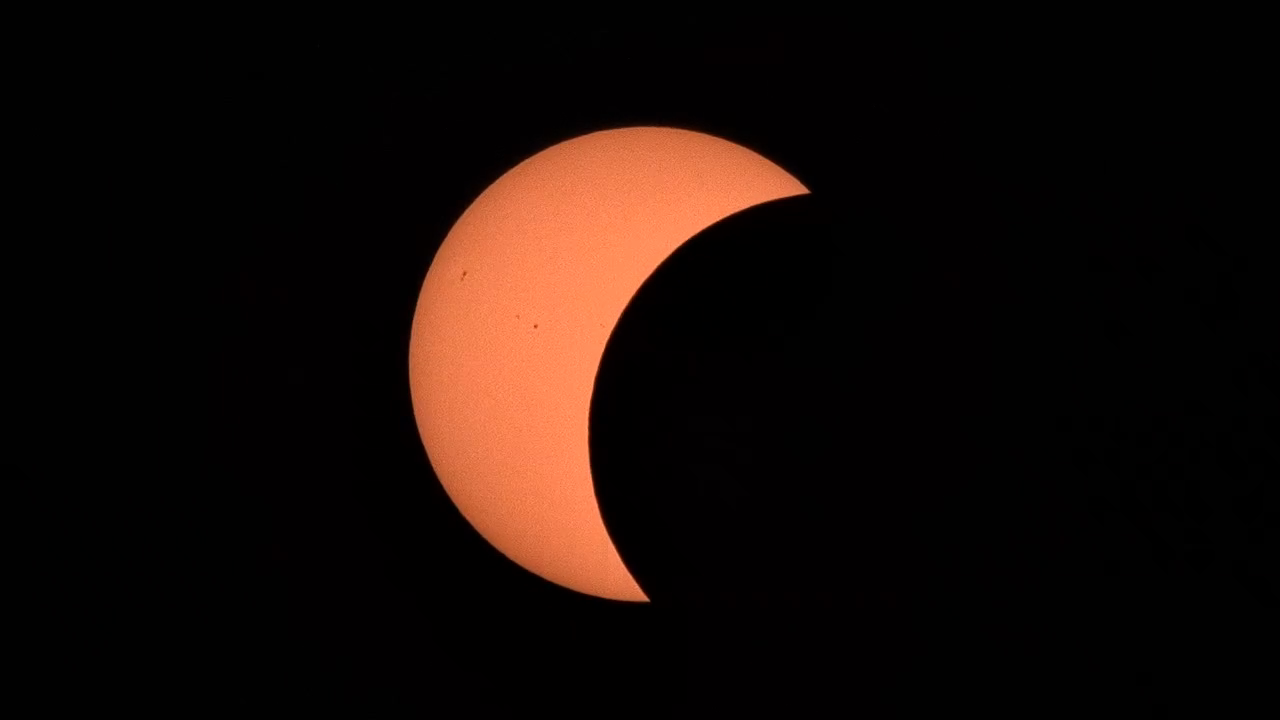 Stage 2 of 5 · About half covered — the Moon advances and the disc narrows to a thick crescent